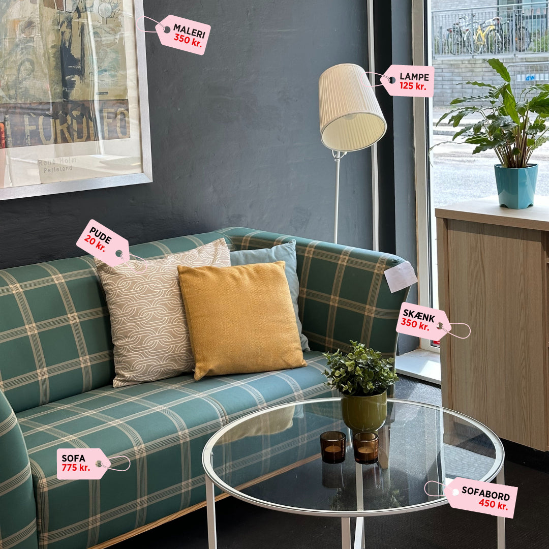 Indretning til studiebolig med sofa, bord, puder, lampe og maleri fra genbrug