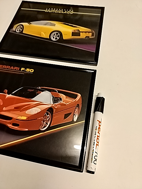 To dejligt støvede 80erbilleder i ramme: Lamborghini og Ferrari.