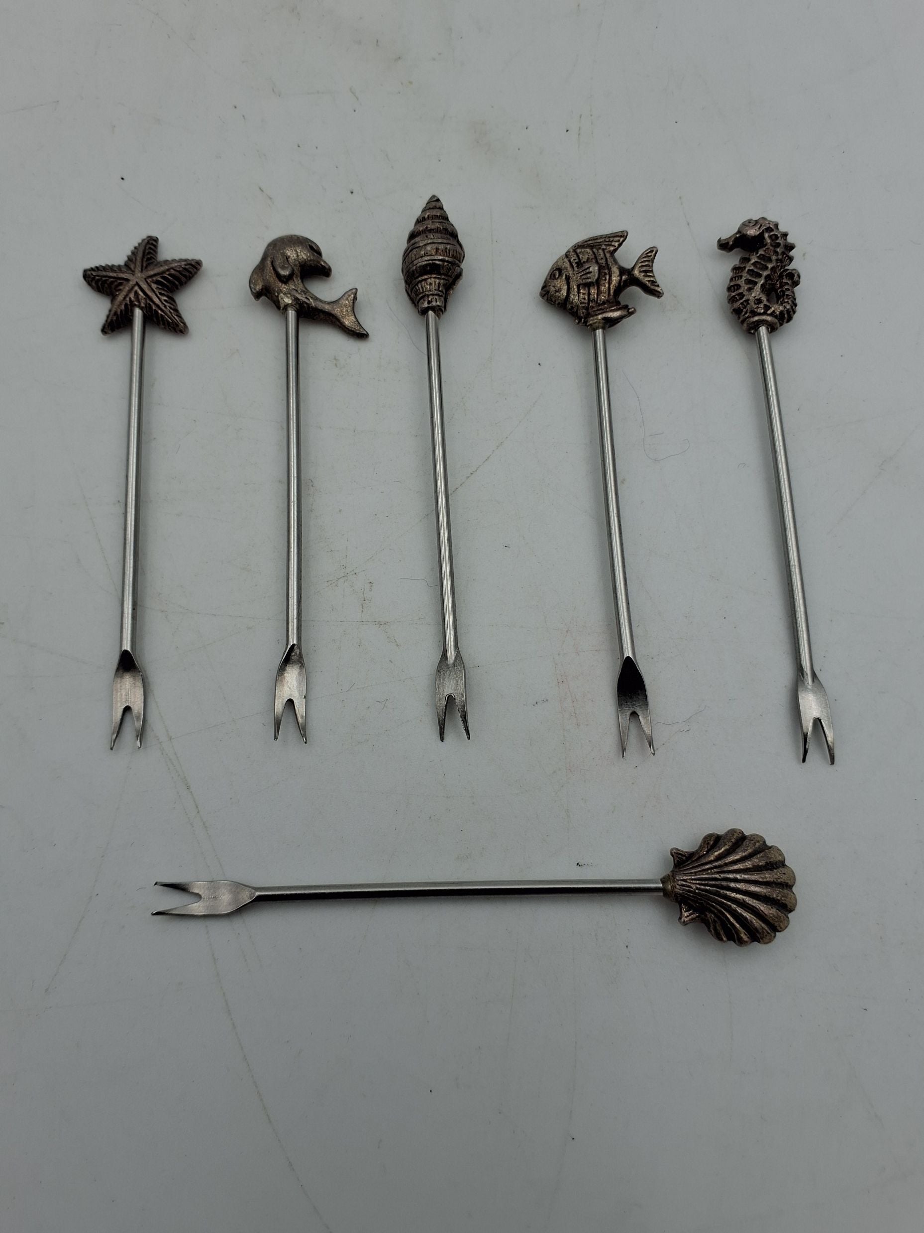 Små metalspyd/cocktailspyd, dekoreret med figurer fra havet