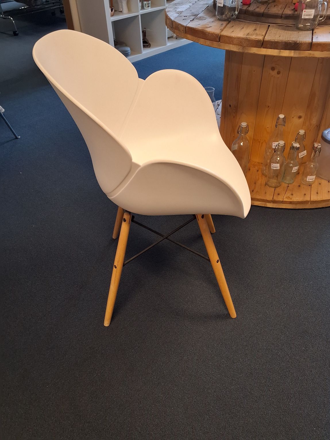 Stol i hvid plastik med træ ben